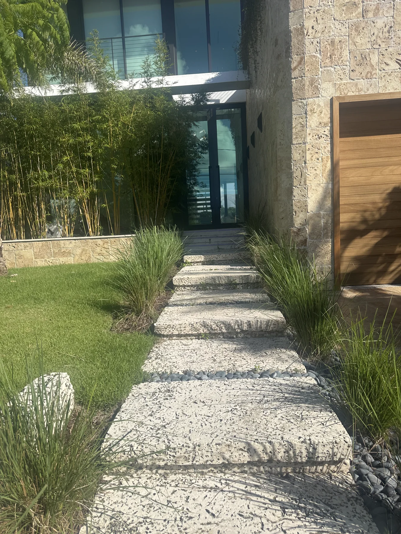 Rough-cut oolite stepping stones leading to a clad Miami Beach home