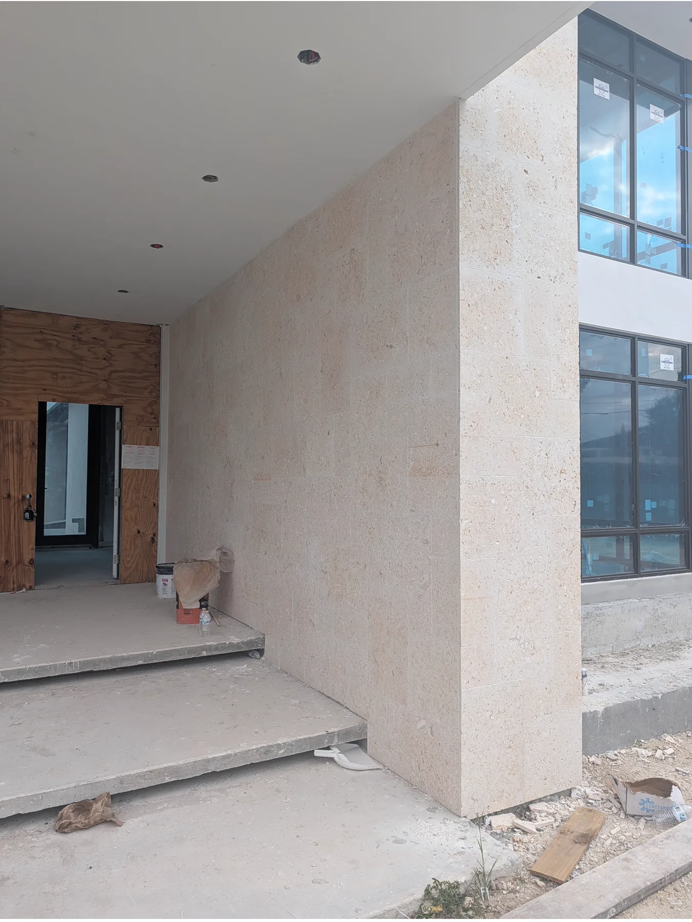 Coral stone walls at the covered entrance of a Pinecrest home