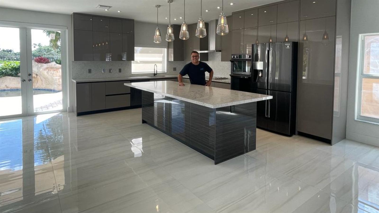 Finished large-format porcelain tile floor in a Miami kitchen and living area