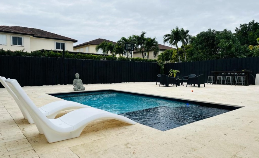 Elegant pool surrounded by coral stone pavers installed by Driveway & Paver Solutions, blending luxury with natural beauty in South Florida.